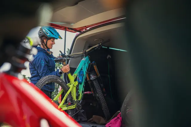 Ein Mountainbiker nimmt sein Fahrrad aus einem Transportfahrzeug.