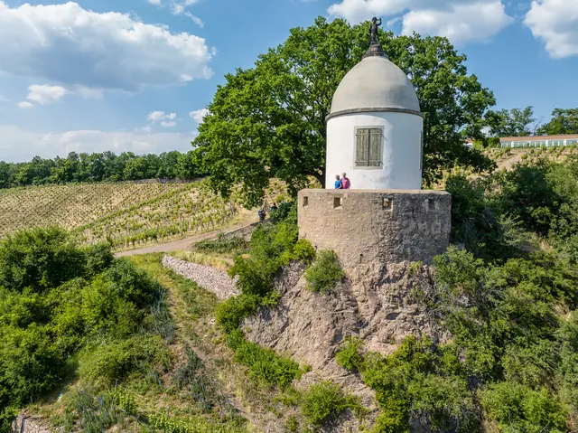 Ein historischer Pavillon steht über terrassierten Weinbergen.