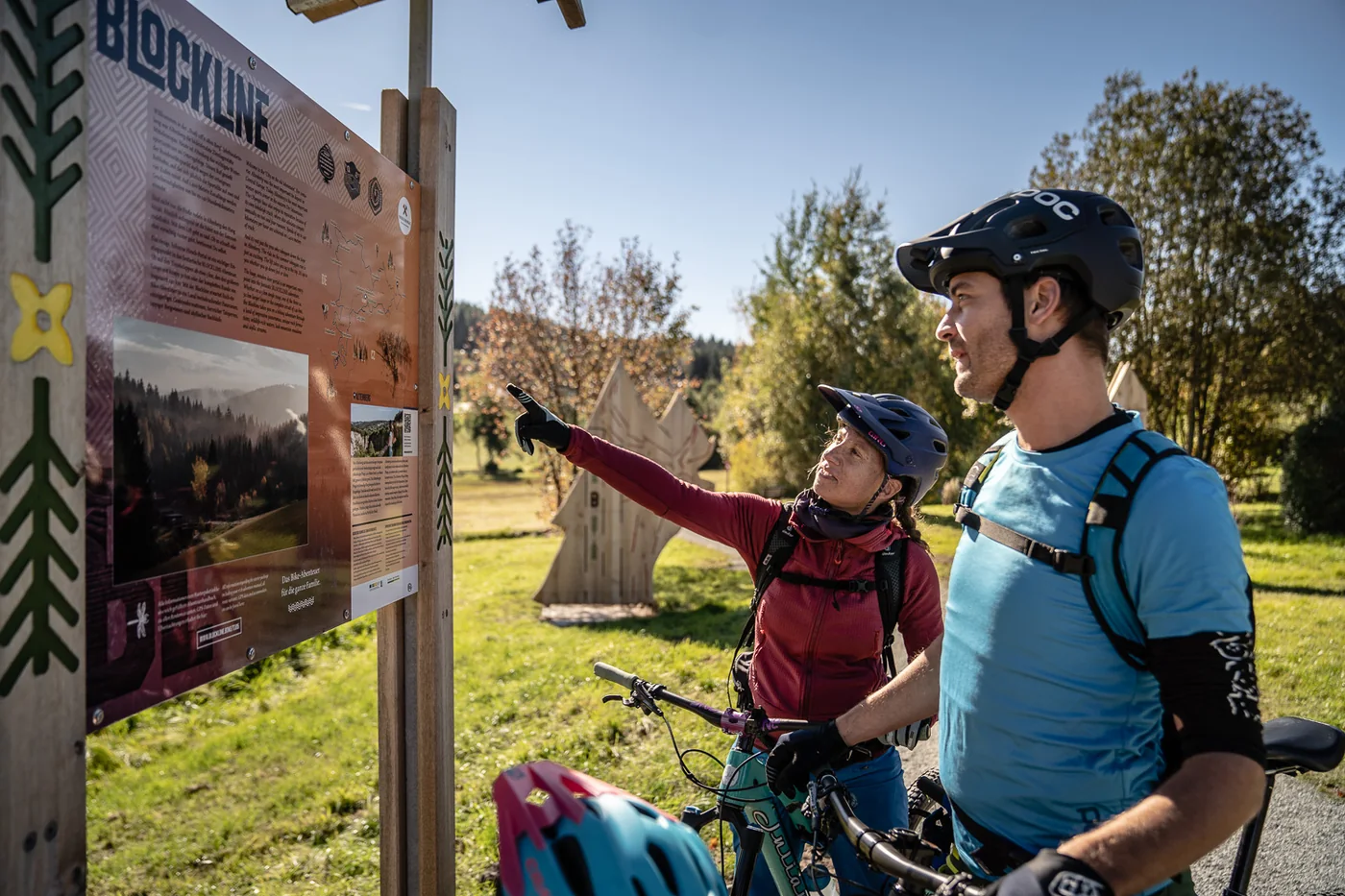 Zwei Mountainbikende orientieren sich an einer Informationstafel der Blockline.